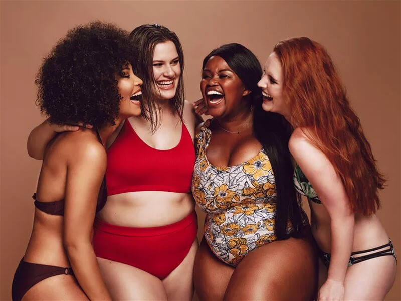 Imagem de quatro mulheres com corpos diferentes, interagindo entre si